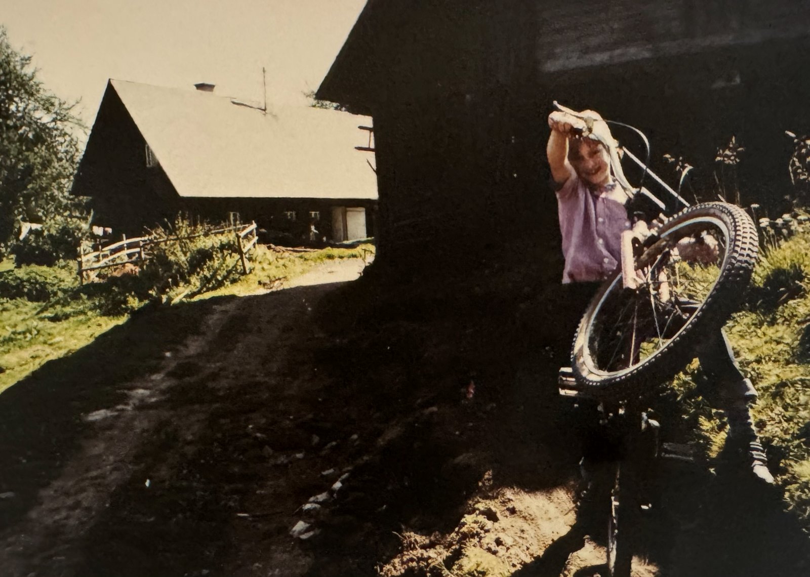 Christian schiebt als Kind sein BMX am Bauernhof